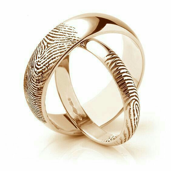 two gold wedding bands with fingerprints on the inside and outside, set against a white background