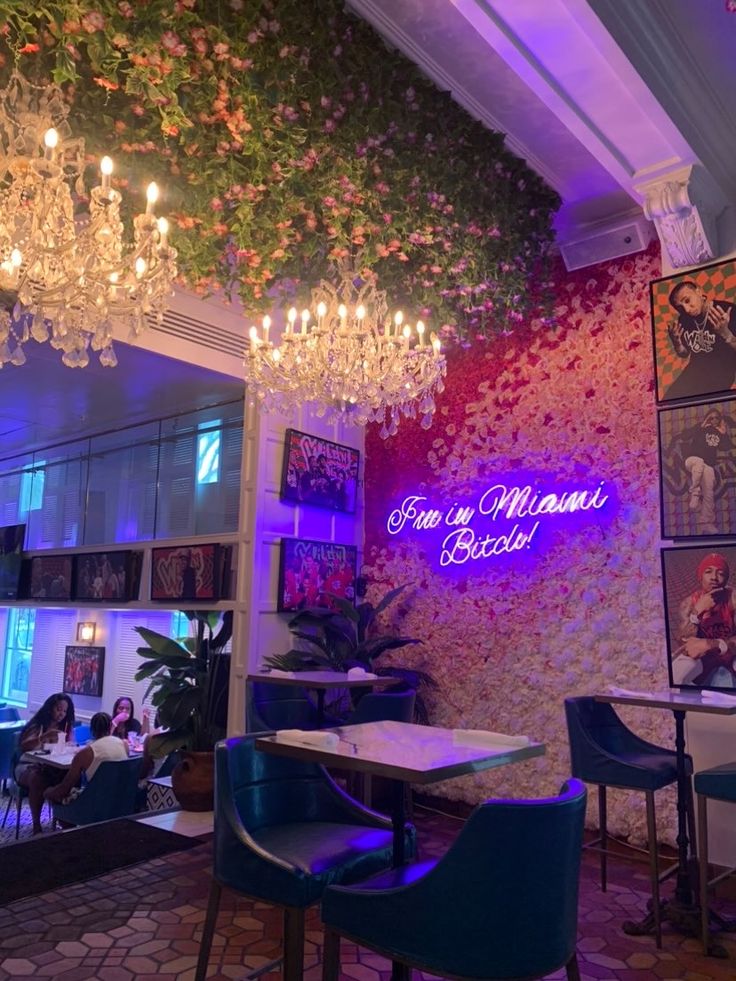 the interior of a restaurant with chandeliers hanging from the ceiling and blue chairs