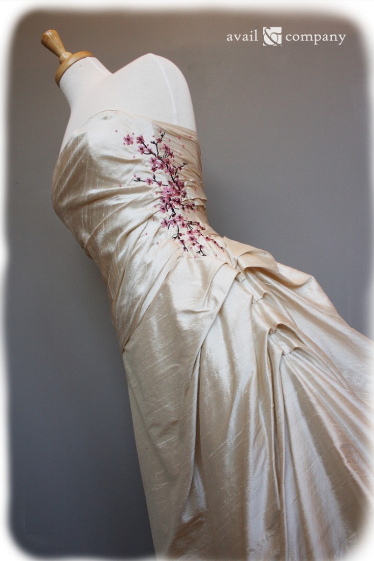 a wedding dress is displayed on a mannequin with an appliqued flower