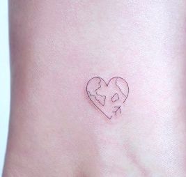 a woman's stomach with a small heart and arrow tattoo on her left side