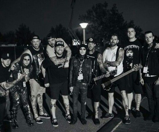 a group of people standing next to each other in front of a street light at night