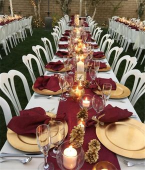 an image of a table set for a wedding with red napkins and gold place settings