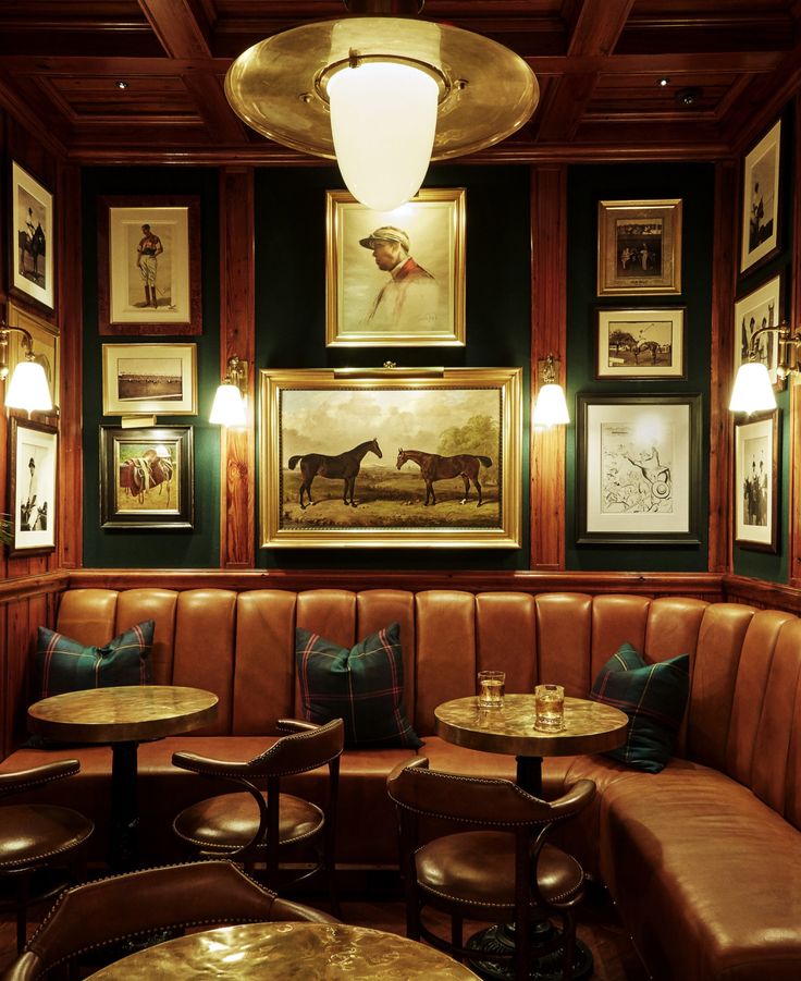 a booth with several tables and chairs in front of pictures on the wall above them