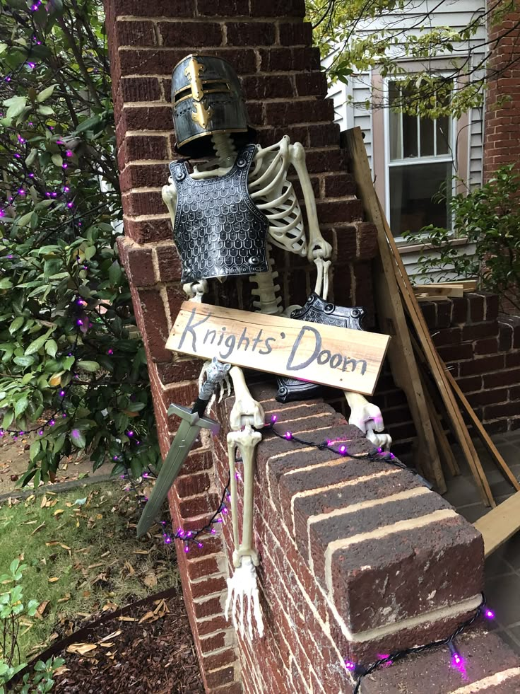 a skeleton sitting on top of a brick wall next to a sign that says knights don't