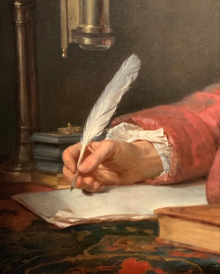 a close up of a person writing on a piece of paper with a quill