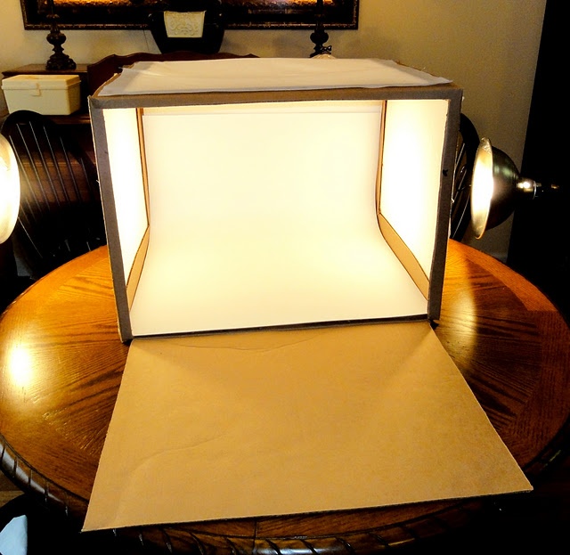 a small light box sitting on top of a table in front of a mirror and lamp