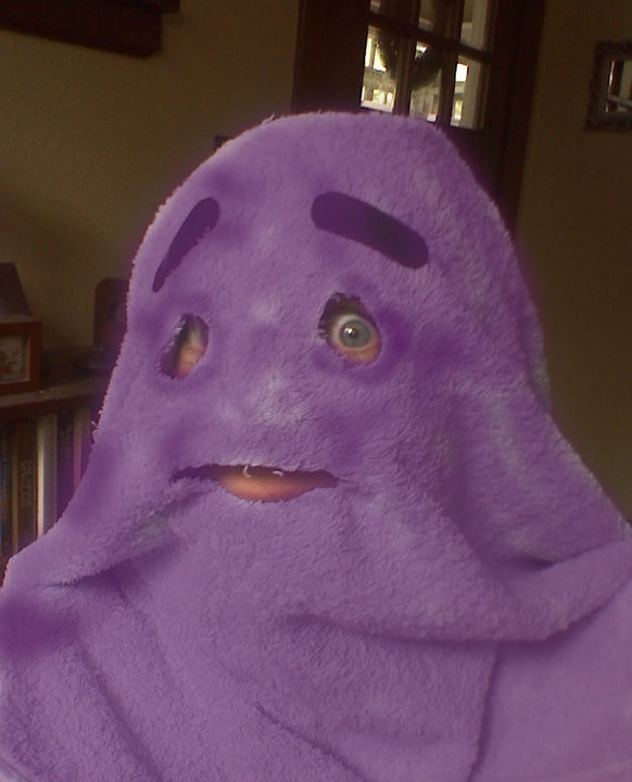 a person in a purple towel with eyes and nose