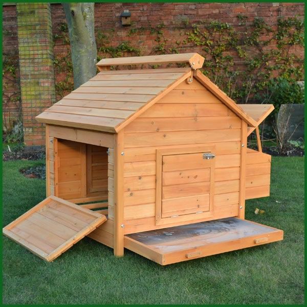 a wooden dog house with steps leading up to the door and side windows on grass