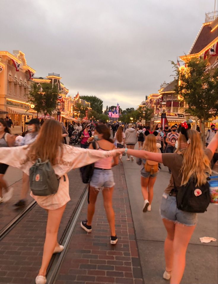 several girls are walking down the street with their arms in the air and one girl is holding her hand out