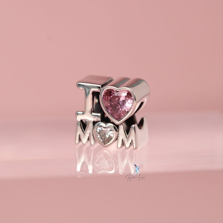 This is charm only, bracelet is sold separately. Give your mother this meaningful gift, the charm features the 3D word I LOVE MOM, made of solid 925 sterling silver and cubic zirconia gem stones, finished with a platinum plating to give it a high end look and long lasting shine. This mother gift charm will fit Pandora bracelet or you can check out our charm bracelet. Jewelry Care: See more information about how to care for your jewelry here. Shipping Policy: Orders will be shipped within 1-3 bus Elegant Sterling Silver Charms For Mother's Day, White Gold Charm Bracelet For Anniversary On Mother's Day, Sterling Silver Charm Bracelet For Mother's Day Anniversary, Sterling Silver Charm Bracelet Gift For Mom, Silver Heart Charm Bracelet For Mom, Sterling Silver Charm Bracelet For Anniversary On Mother's Day, Sterling Silver Charm Bracelet As Gift For Mom, Silver Sterling Charm Bracelet As Gift For Mom, Valentine's Day White Gold Sterling Silver Charms