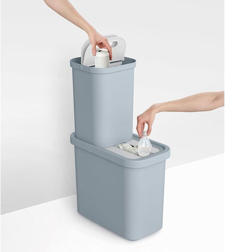 two trash cans are shown with their lids open and one is holding something in it