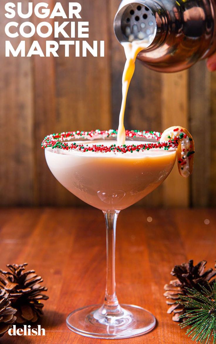 a drink being poured into a glass with sugar and sprinkles on it