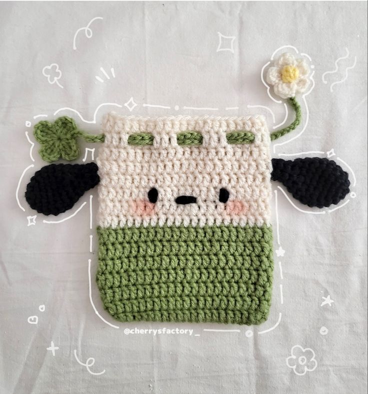 a crocheted bag with a cow on it and a flower in the middle