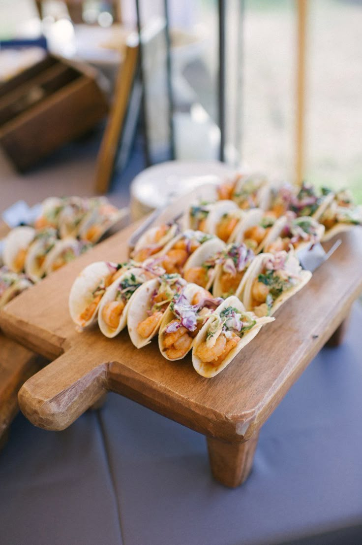 some tacos are sitting on a cutting board and ready to be served at a party