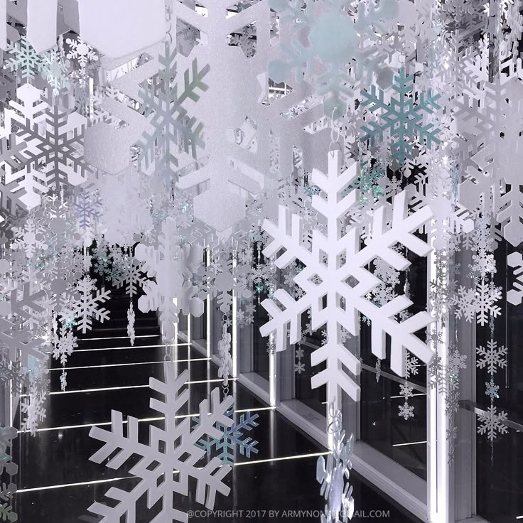 snowflakes are floating in the air on a black and white background with silver lines