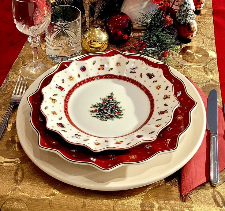 a plate with a christmas tree on it is sitting on a table next to silverware