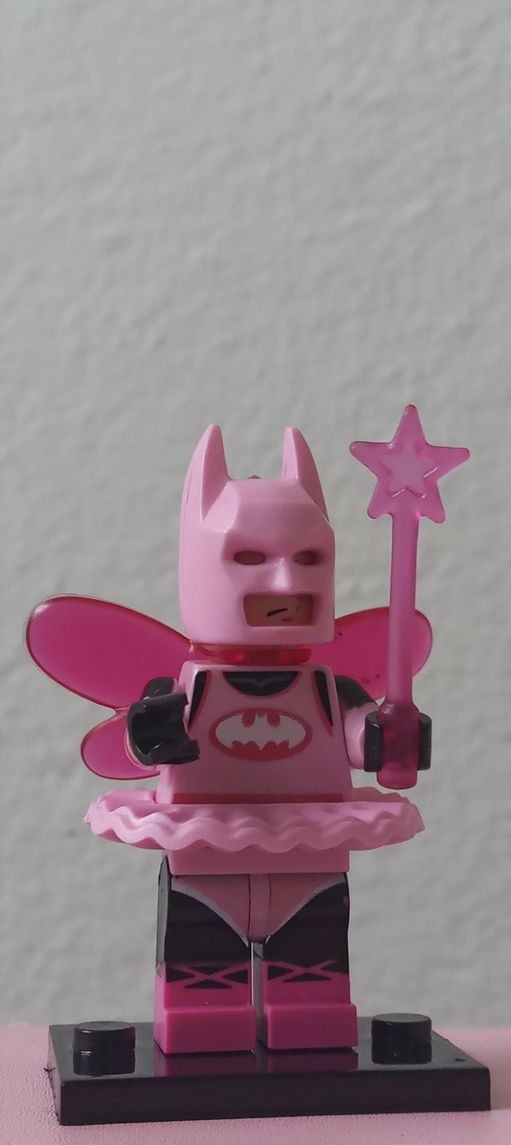 a pink batgirl minifigure holding a star