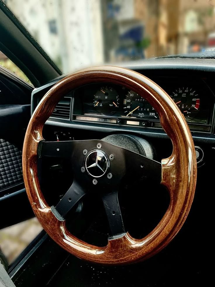 the steering wheel and dashboard of an old car with wood grained dash tape on it