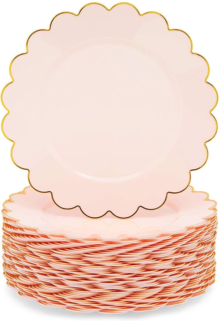 a stack of pink and gold plates with scalloped rims on top of each plate