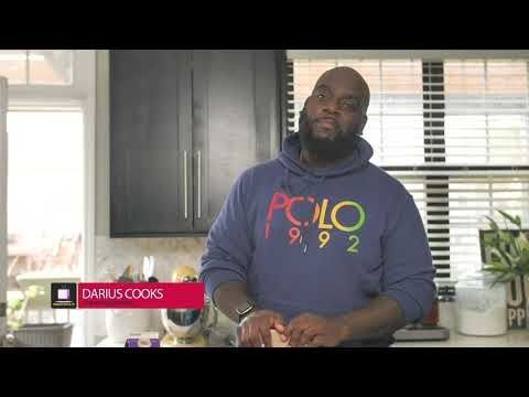 a man in a blue hoodie standing in a kitchen