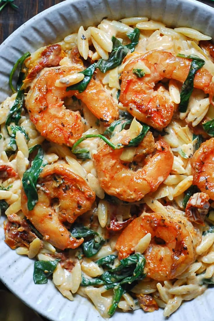 pasta with shrimp and spinach in a white bowl