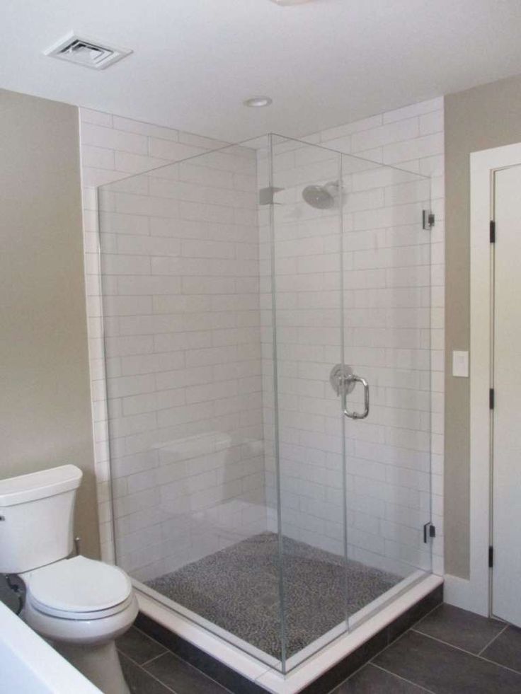 a white toilet sitting next to a walk in shower