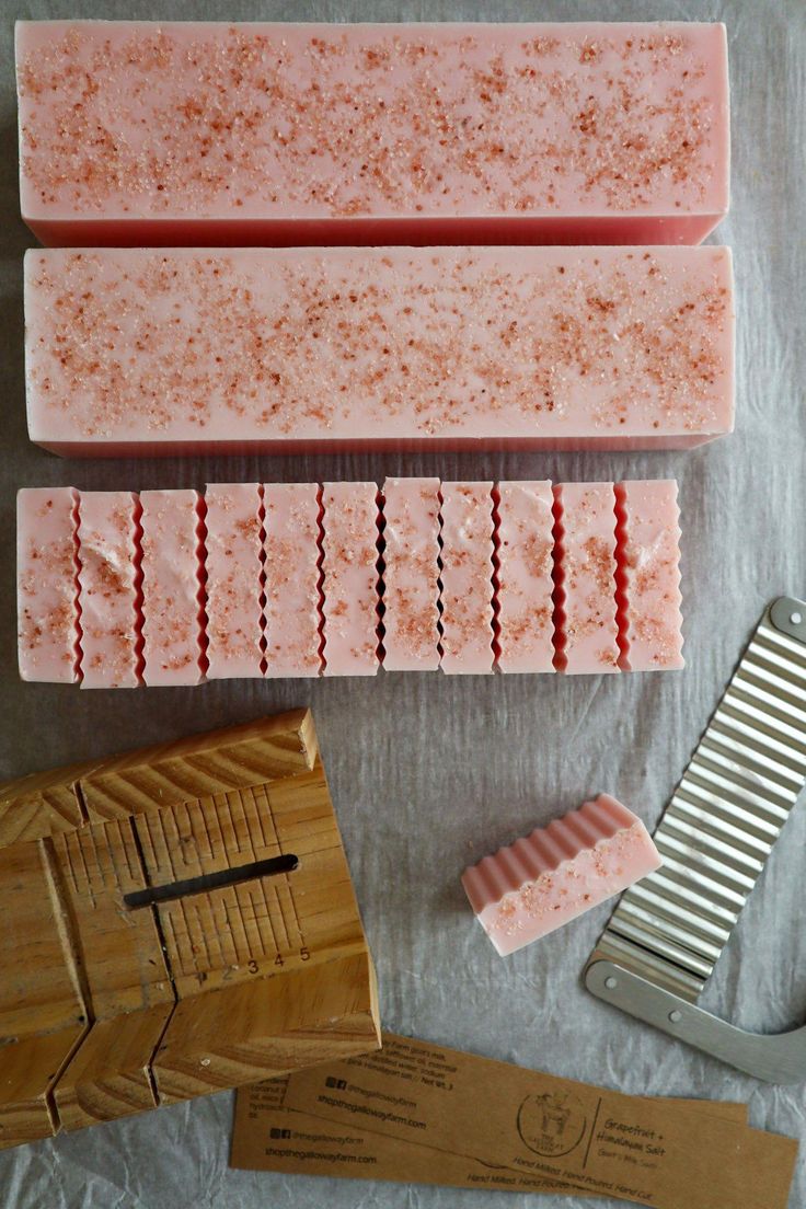 three bars of soap sitting on top of a table next to a comb and paper