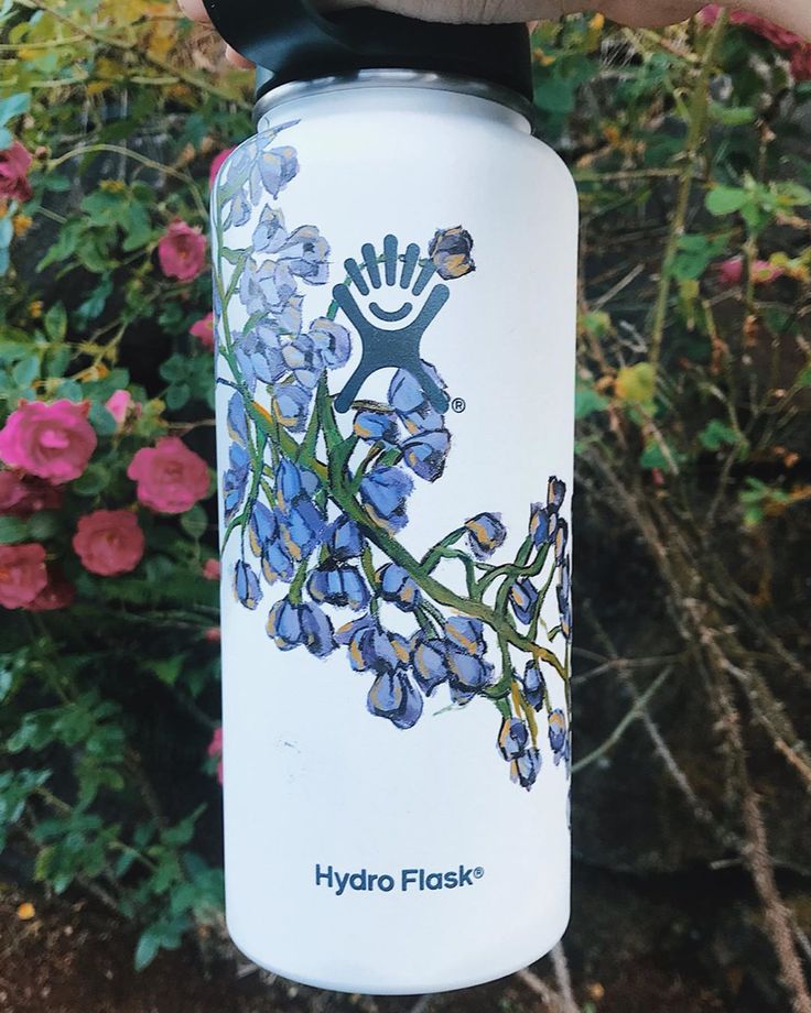 a hand holding a hydro flask with flowers on it