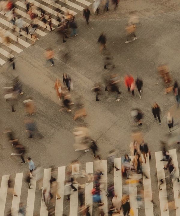 an aerial view of people walking across a crosswalk