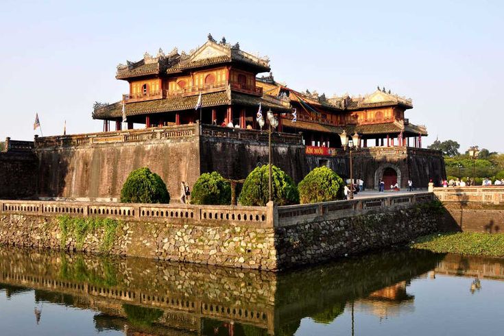 an old building with lots of windows next to water