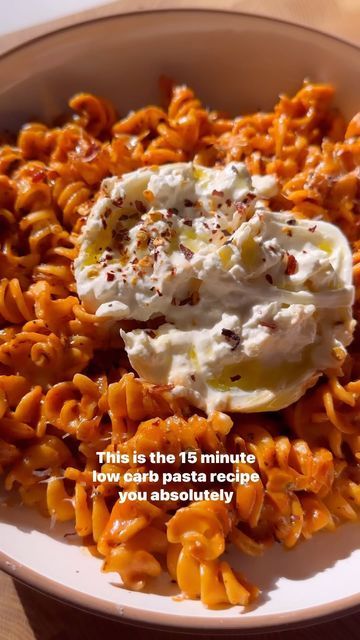 a bowl filled with pasta and sauce on top of a table