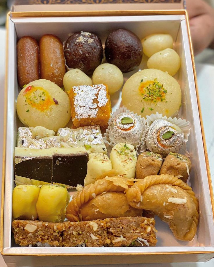 a box filled with different types of pastries and desserts on top of a table