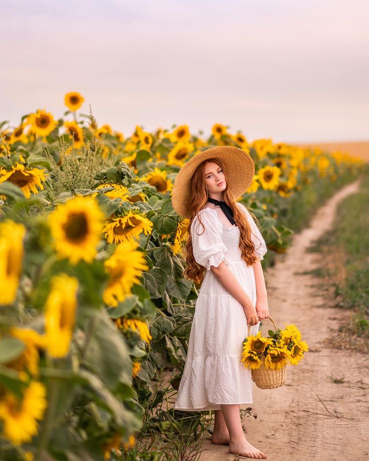 a woman in a sunflower field holding a basket