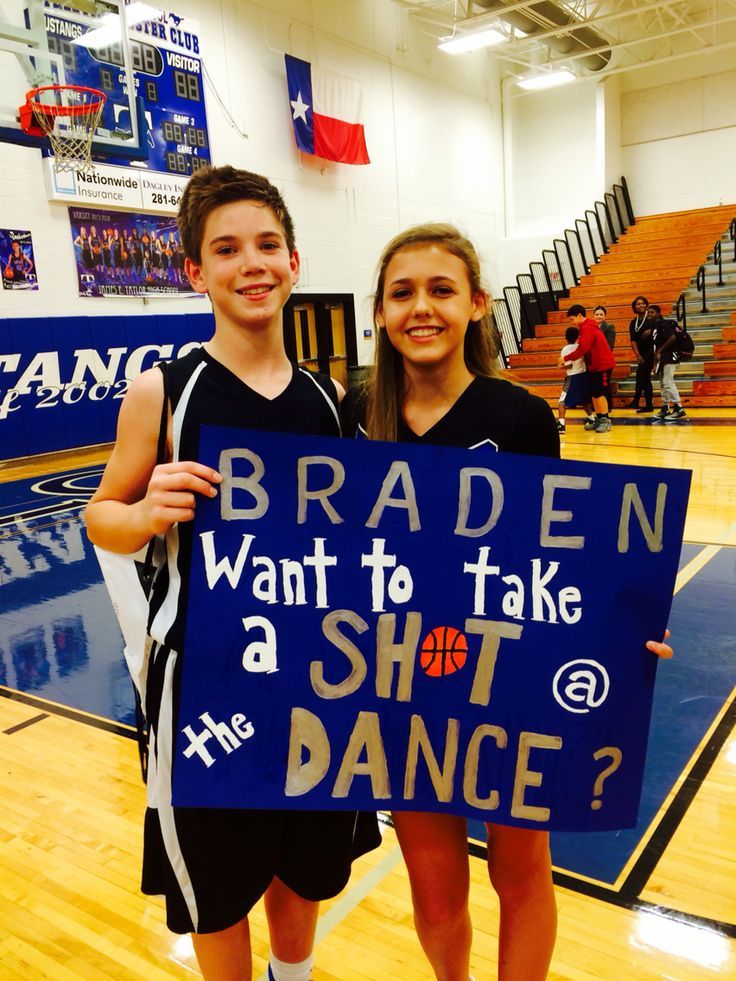 two young people holding up a sign that says braden want to take a shot dance?