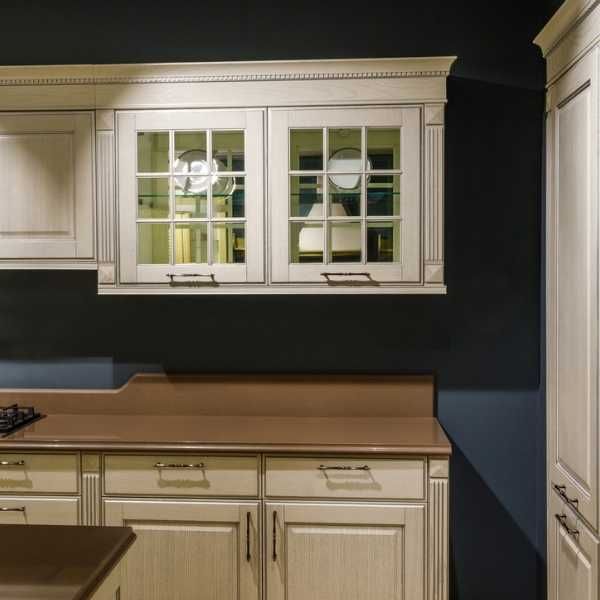 a kitchen with white cabinets and wooden counter tops in the middle of dark blue walls