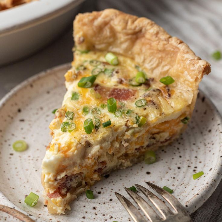 a slice of quiche on a plate with a fork