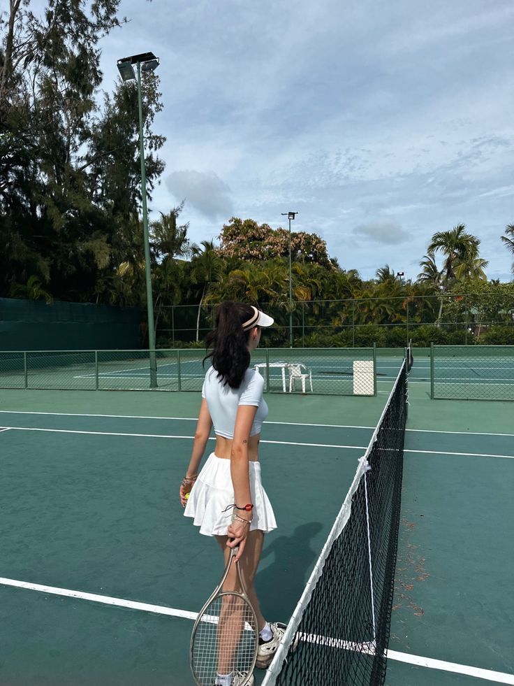 a woman standing on a tennis court holding a racquet