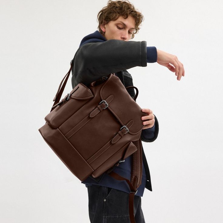 a young man is holding a brown briefcase