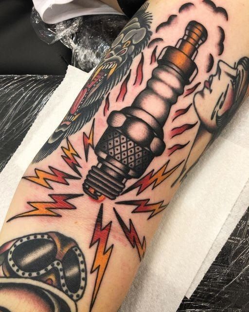 a man with a tattoo on his arm has an image of a car engine in the background