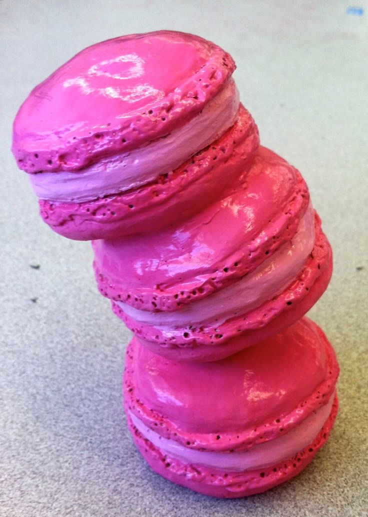 a stack of pink macaroons sitting on top of a counter next to each other