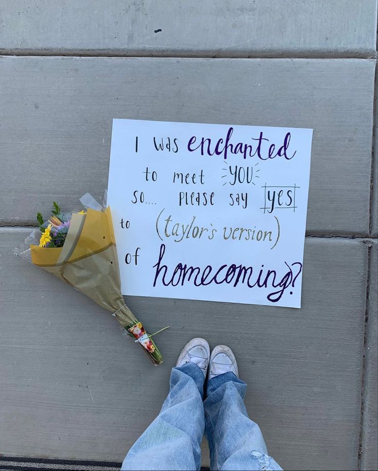 someone has written a note on the ground with flowers and a bouquet next to it