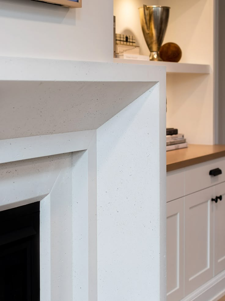 a fireplace with white cabinets and a painting on the wall