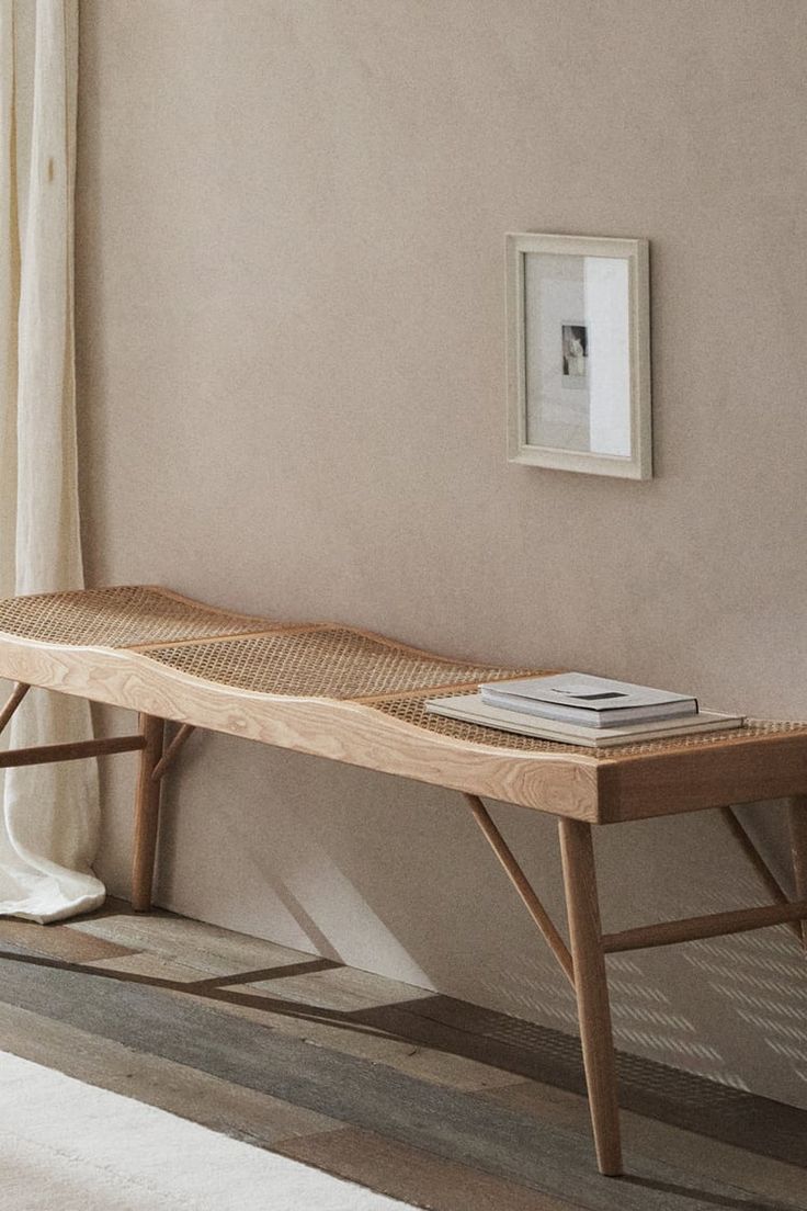 a wooden bench sitting in front of a window next to a white rug on top of a hard wood floor