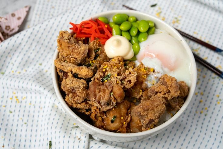 a bowl filled with meat and vegetables on top of a table