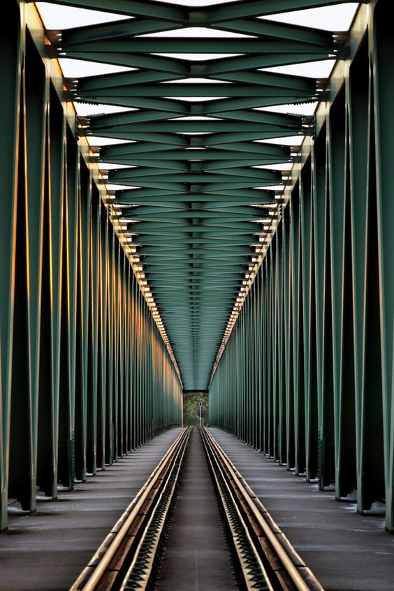 an image of a train track that is going through the middle of a tunnel with lots of poles