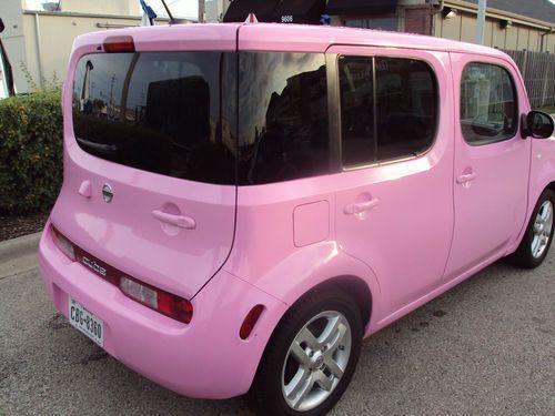 a pink car is parked on the street