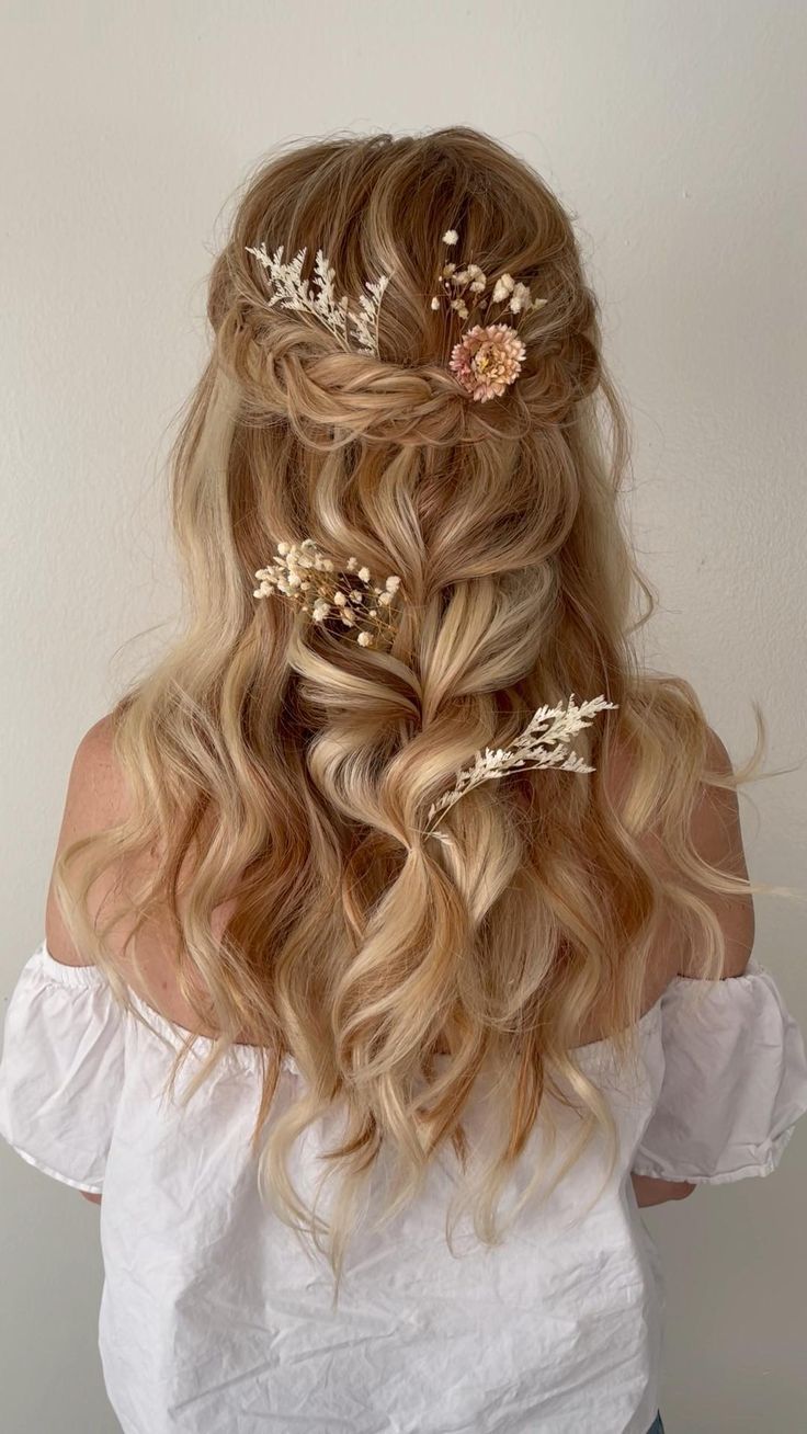 a woman with long blonde hair and flowers in her hair is shown from the back