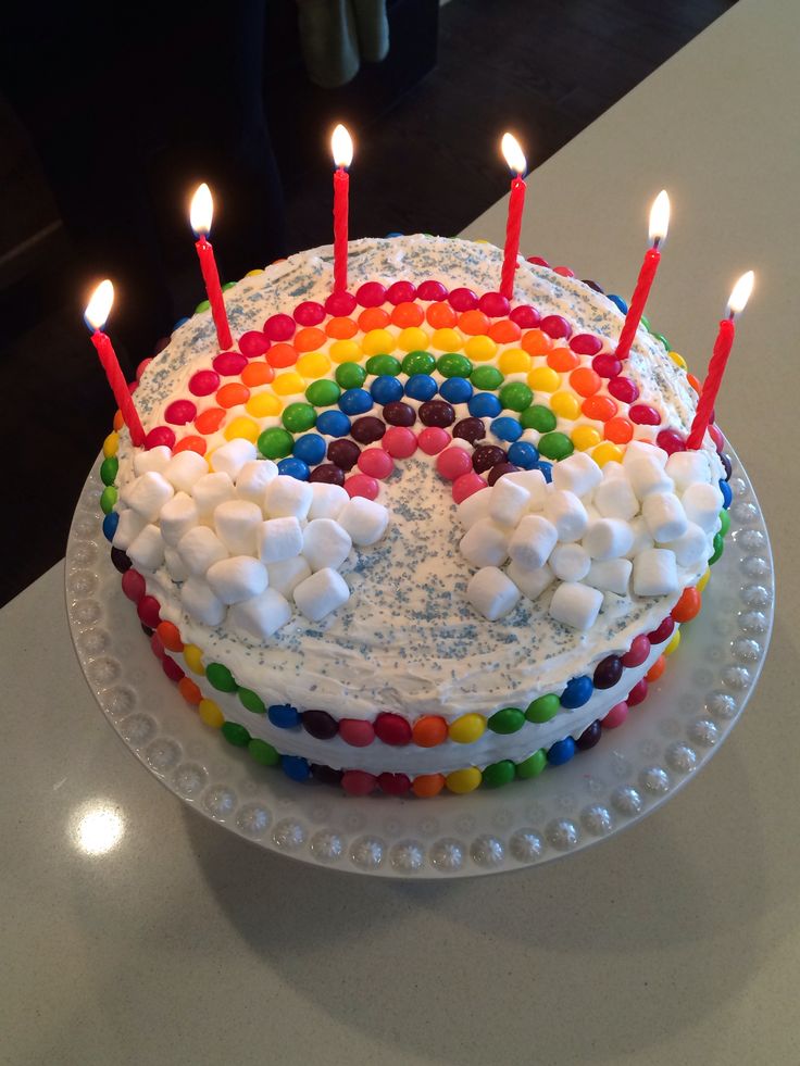 a birthday cake with marshmallows and rainbow frosting