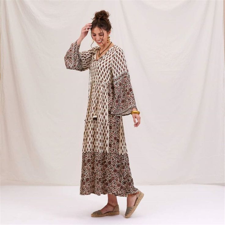 Step into boho bliss with the Julia Ecru & Black Bohemian Tiered Dress! Made from a dreamy blend of 50% modal and 50% viscose, this dress drapes beautifully for a flattering, comfortable fit. The playful full-length bell sleeves add a touch of elegance, while the open neck design keeps your look effortlessly chic. Fall in love with the unique details, like the long decorative tassels with cute accents and the contrasting design on the sleeves and bottom of the dress. With its ankle-length flow, Flowy Boho Print Rayon Maxi Dress, Flowy Rayon Maxi Dress With Boho Print, Flowy Bohemian Boho Dress For Fall, Fall Bohemian Flowy Boho Dress, Boho Maxi Dress In Rayon With Boho Print, Flowy Boho Print Midi Dress In Rayon, Maxi Length Boho Dress With Boho Print In Rayon, Maxi Length Rayon Boho Dress With Boho Print, Maxi Length Boho Dress With Boho Print