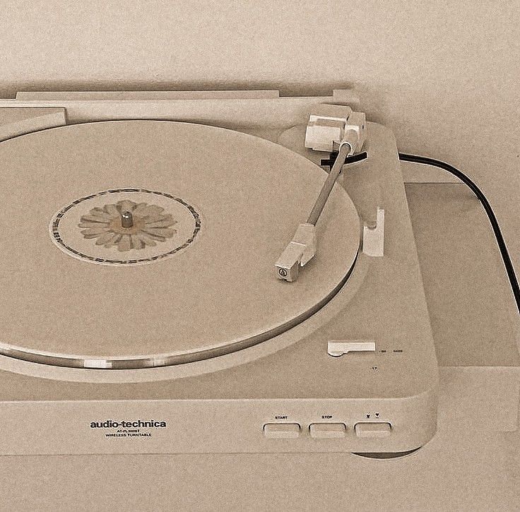 an old record player sitting on top of a white box with wires plugged into it